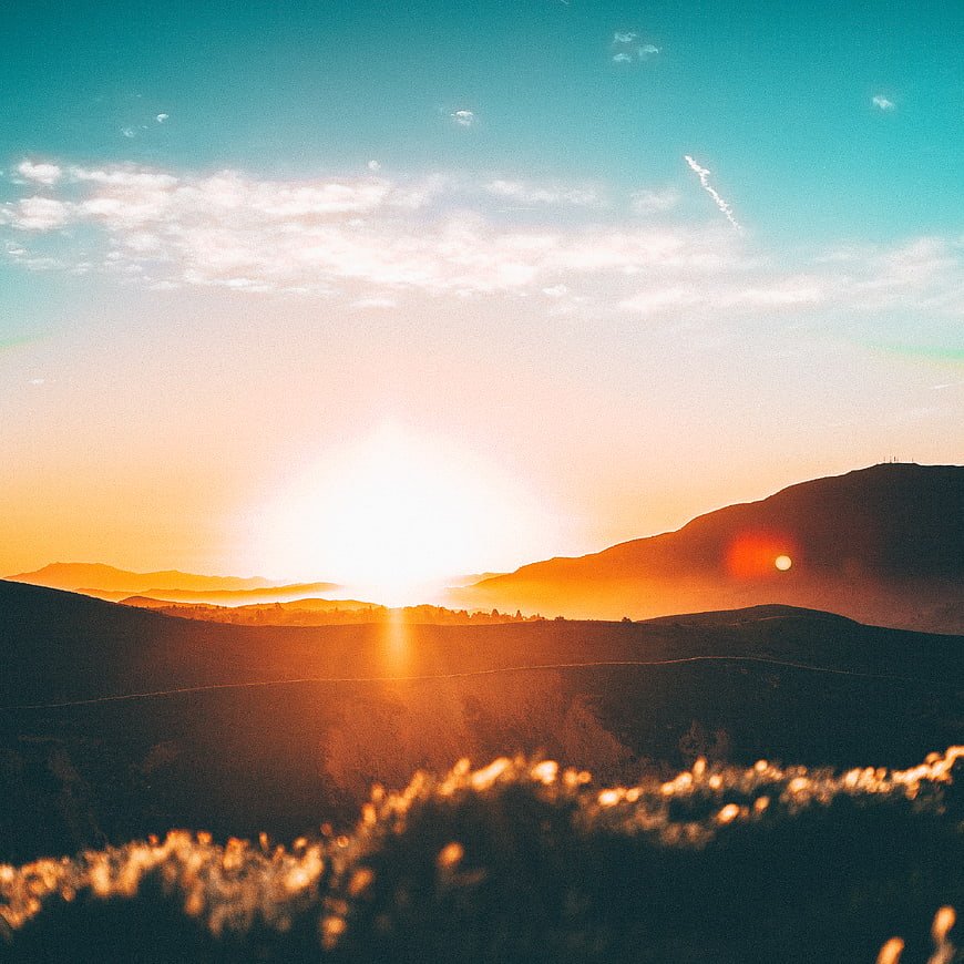 Golden Sunrise Over Rolling Hills and Mountain Landscape