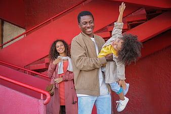 Happy African American family playing on red stairs outdoors
