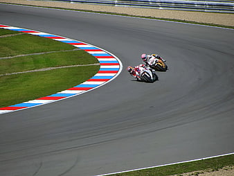 Two Motorcyclists Racing on a Curved Track