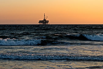 Offshore Oil Rig Silhouette on Ocean Horizon at Sunset