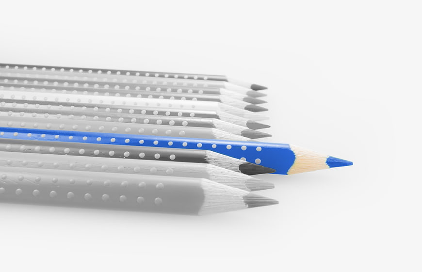 Blue Pencil Standing Out Among Grey Pencils on White Background