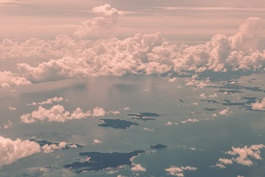 Aerial view of tropical islands and ocean with pink clouds
