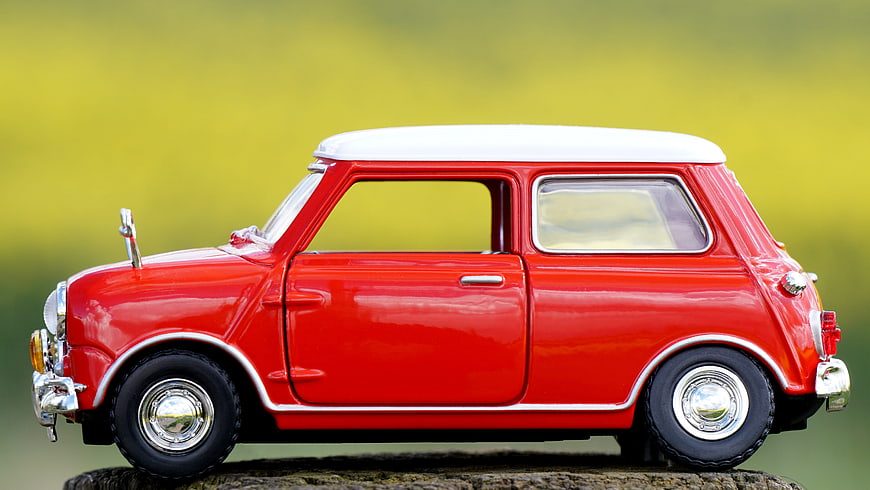 Red Mini Cooper Model Car on Wooden Log