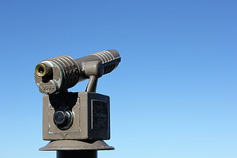 Vintage Coin-Operated Binoculars Against Blue Sky