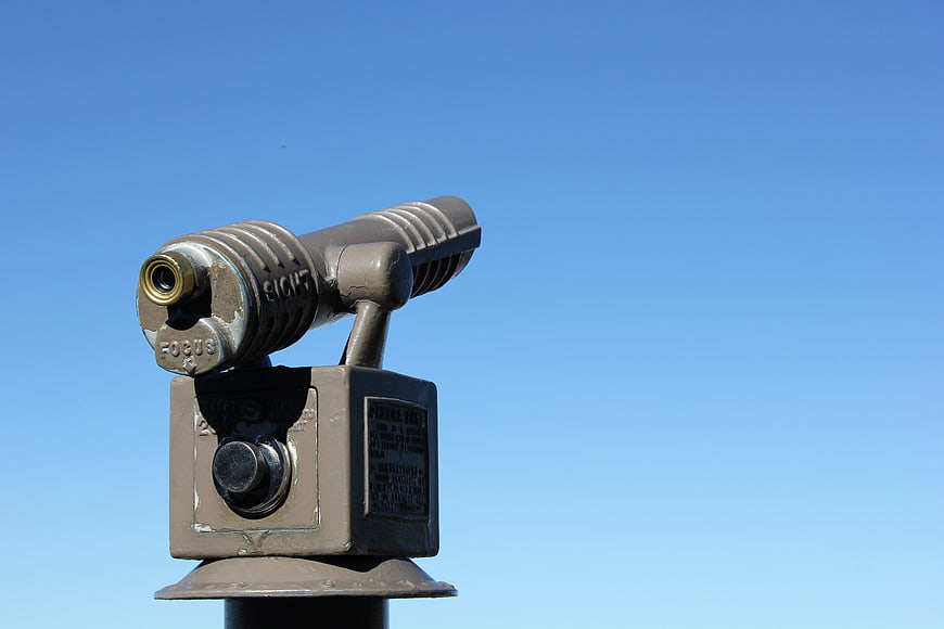 Vintage Coin-Operated Binoculars Against Blue Sky