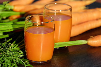 Fresh Carrot Juice in Glasses with Raw Carrots