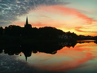 Silhouette of Church Spire Reflected in River at Sunset