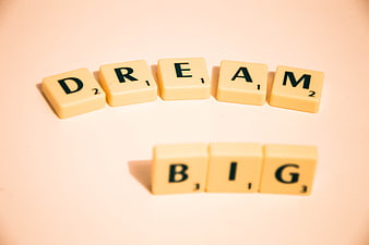 Scrabble Tiles Spelling Dream Big on Beige Background