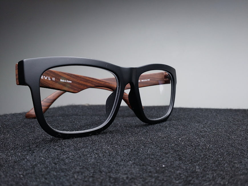 Black and Wood Eyeglasses on Dark Textured Surface