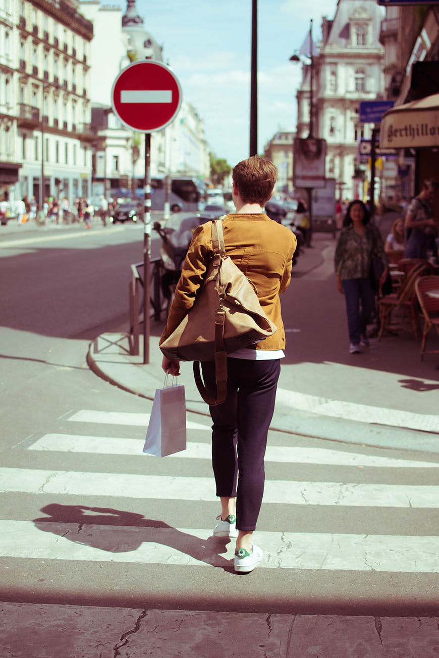 Woman with Shopping Bag Crossing City Street