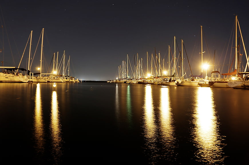 Sailboats in Marina at Night with Golden Reflections