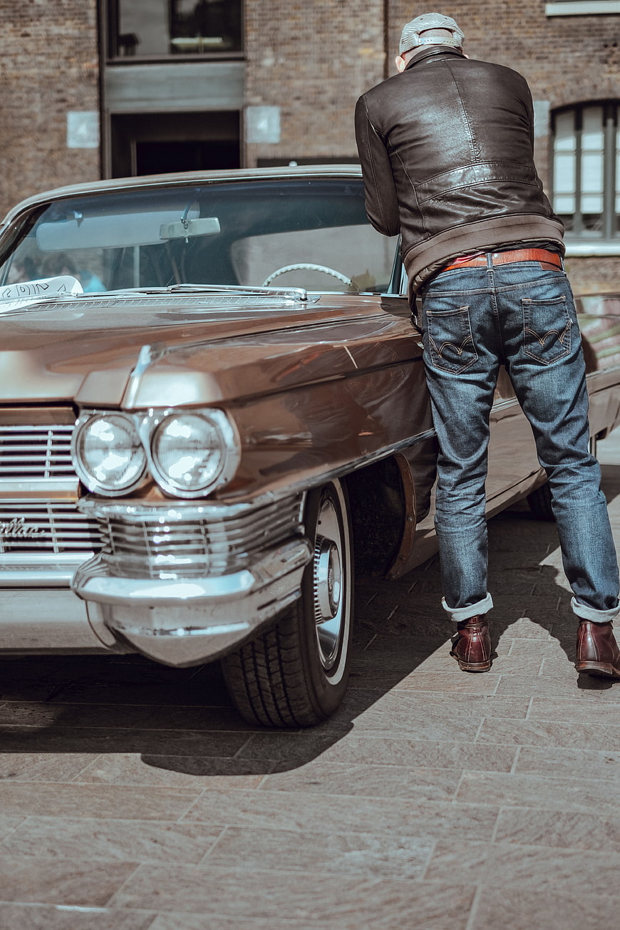 Man in Leather Jacket Inspecting Vintage Classic Car