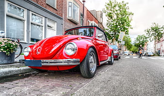 Classic Red Volkswagen Beetle Convertible Parked on Cobblestone Street