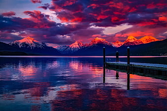 Dramatic Sunset Over Lake with Dock and Snowy Mountains