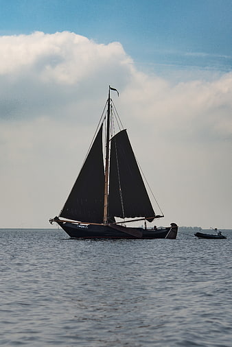 Traditional Black Sailboat on Calm Blue Water