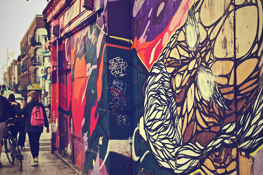 Woman Walking Past Vibrant Street Art Mural