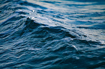 Close-up of deep blue ocean waves with sparkling sunlight