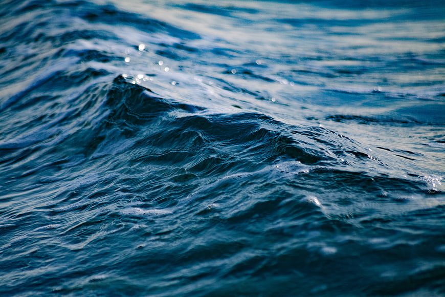 Close-up of deep blue ocean waves with sparkling sunlight