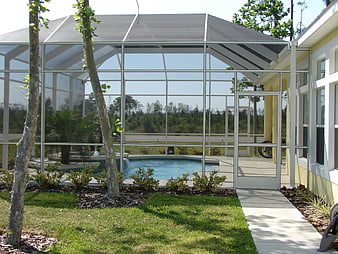 Screened-in backyard patio with swimming pool and modern house exterior