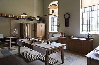 Historic Victorian Kitchen Interior With Copper Utensils And Wooden Table