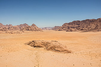 Vast desert landscape with red rock formations and blue sky