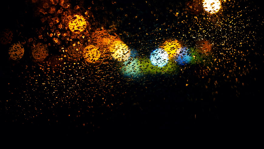 Abstract Bokeh Lights Through Raindrops on Glass