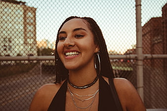 Smiling Woman with Braids in Urban Setting