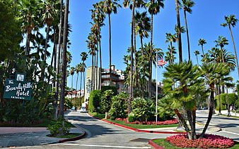 The Beverly Hills Hotel Entrance With Palm Trees And Blue Sky