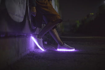 Person wearing white LED light-up sneakers at night