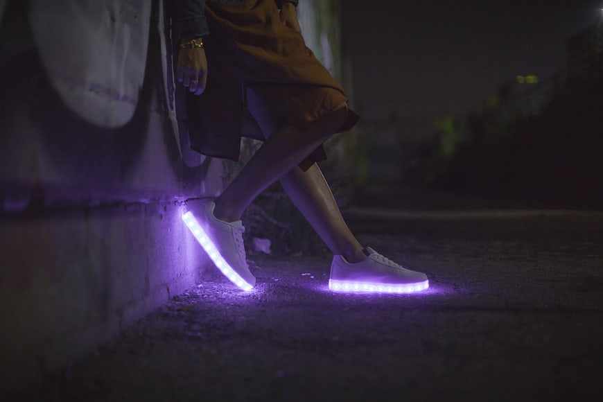 Person wearing white LED light-up sneakers at night