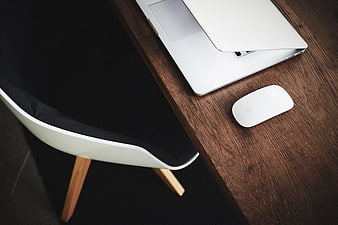 Minimalist workspace with laptop and mouse on wooden desk