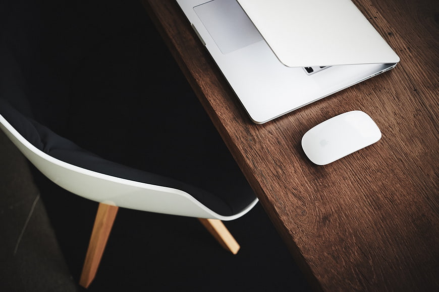 Minimalist workspace with laptop and mouse on wooden desk