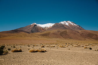 Snow-Capped Volcanic Mountain in Arid Desert Landscape