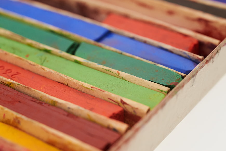 Close-up of colorful chalk pastels in a wooden box