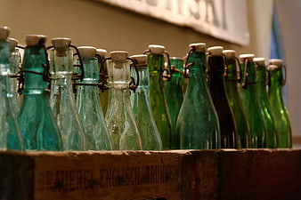 Vintage green glass swing-top bottles in wooden crate