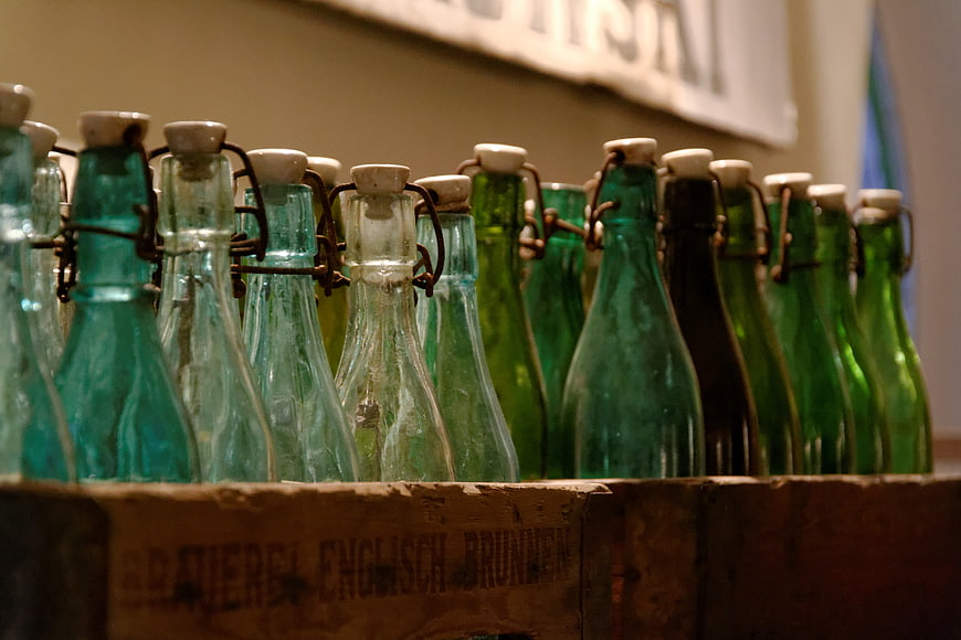 Vintage green glass swing-top bottles in wooden crate