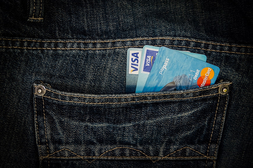 Credit cards in dark denim jeans pocket close-up