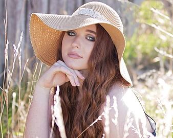 Portrait of a Redhead Woman in a Straw Hat in a Field