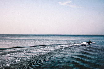 Jet Ski Rider on Calm Blue Ocean with Large Copyspace