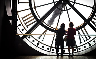 Two women silhouetted against giant clock face at Musée d'Orsay