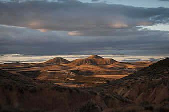 Dramatic desert landscape with golden hour light on hills