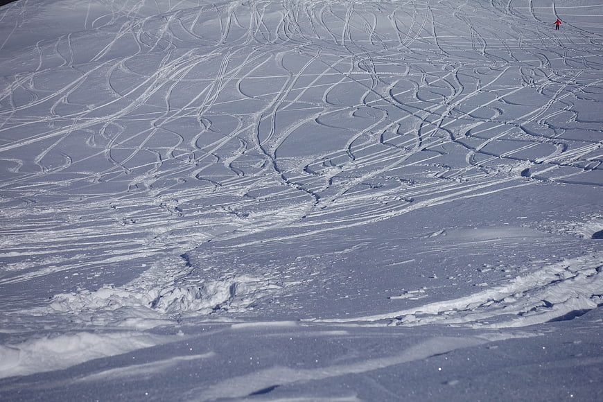 Aerial view of deep snow ski tracks on a mountain slope