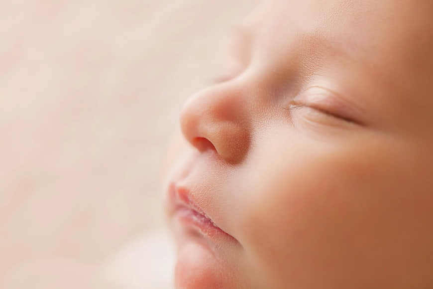 Close-up of sleeping baby face with soft skin texture