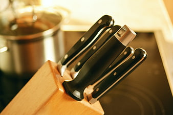 Close-up of black kitchen knives in a wooden block