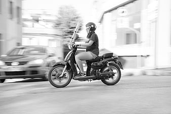 Woman riding scooter in motion black and white
