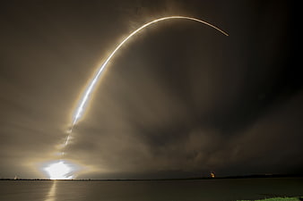 Rocket Launch Trajectory Arc Over Water At Night