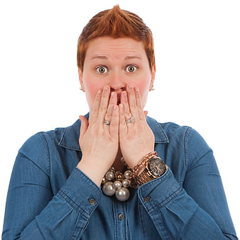Shocked woman with hands over mouth on white background