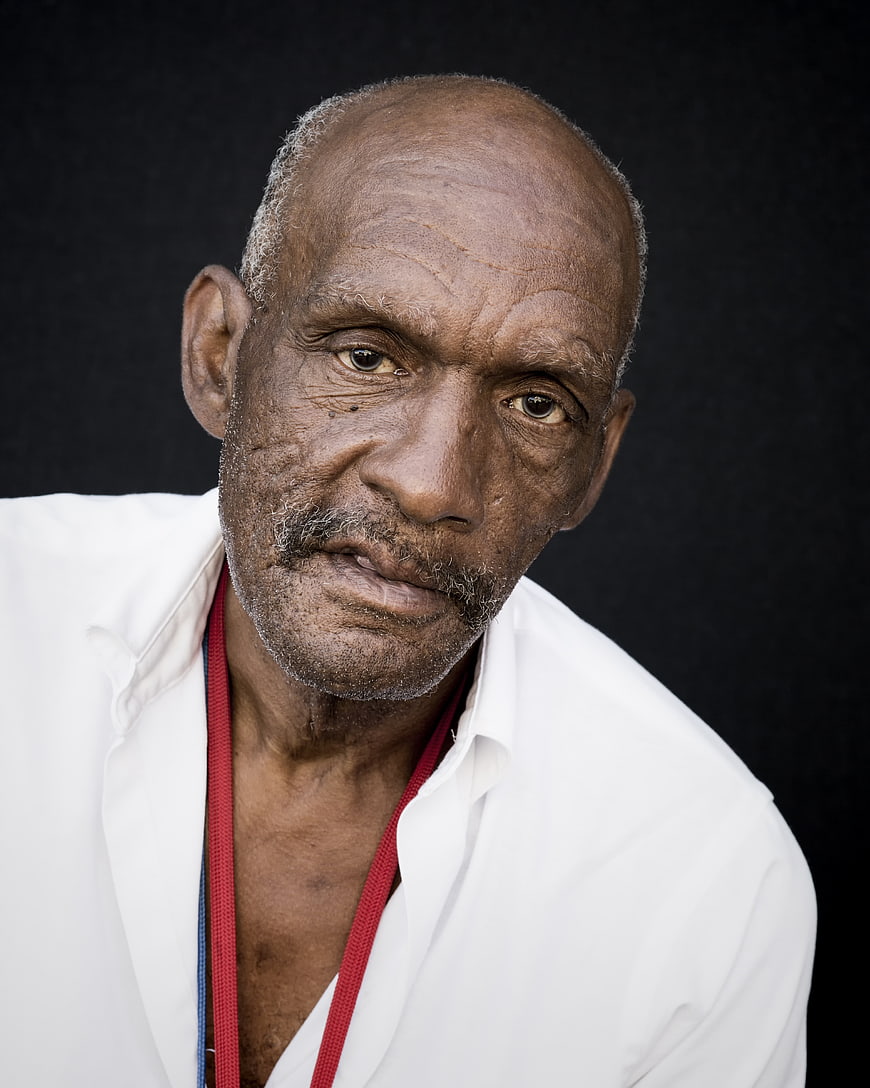 Portrait of an elderly Black man in a white shirt