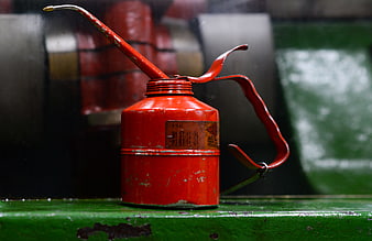 Vintage Red Oil Can on Green Surface