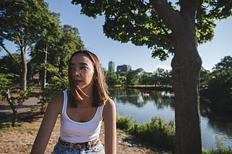 Young woman portrait in park with lake background